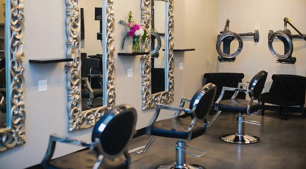 Elegant salon interior at Tangled Hair Boutique, Elmhurst, Illinois, US with ornate mirrors and styling chairs.