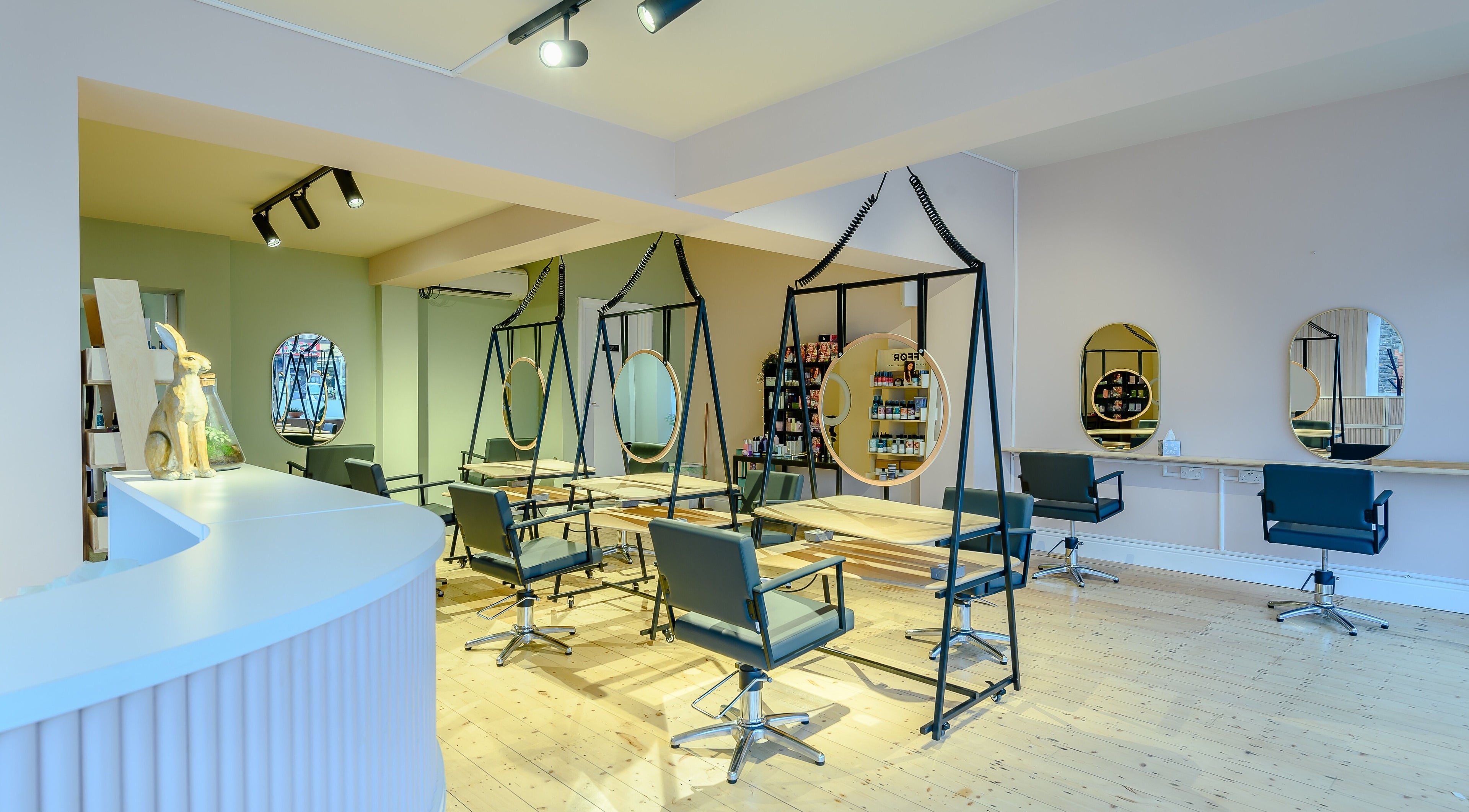 Chic salon interior at Henderson & Co, Cardiff, Wales, GB, showcasing stylish chairs and modern mirrors.