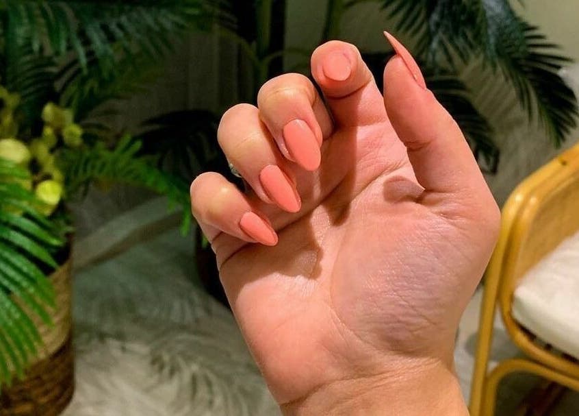 Coral manicured nails at Last Touch Salon, Dammam, Eastern Province, SA, showcasing beauty and wellness.