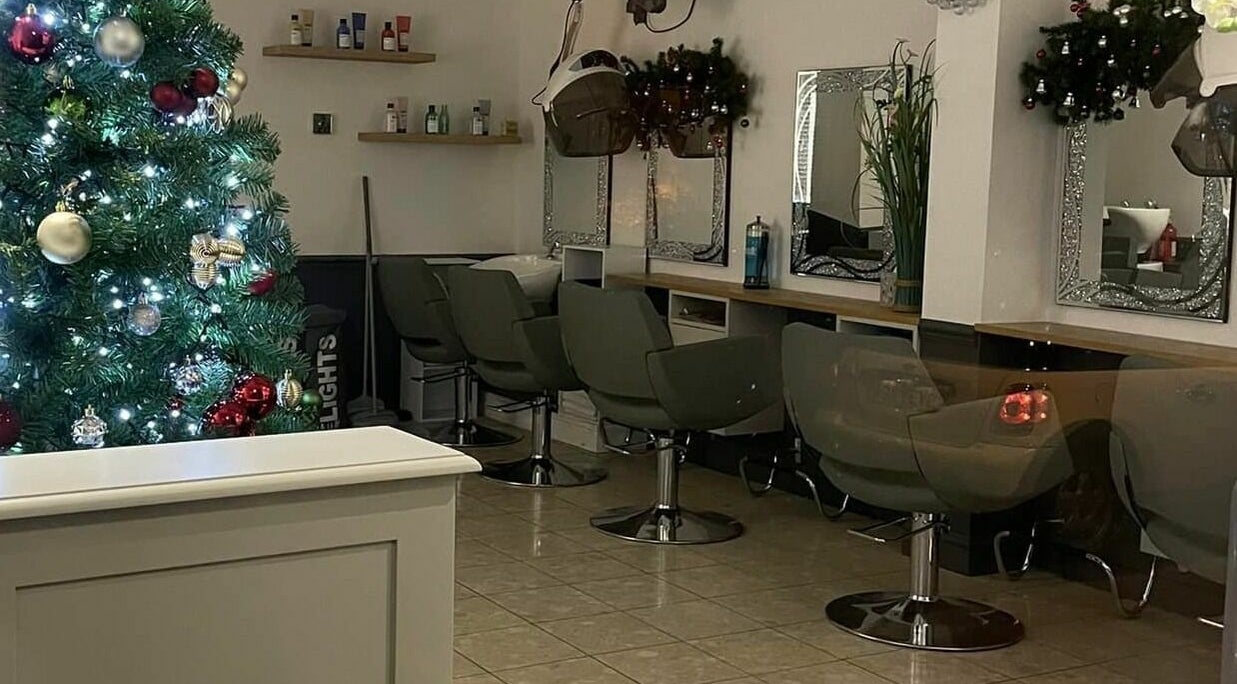 Corner Hairdressing in Lindfield, England, GB, decorated with a Christmas tree next to salon chairs and mirrors.