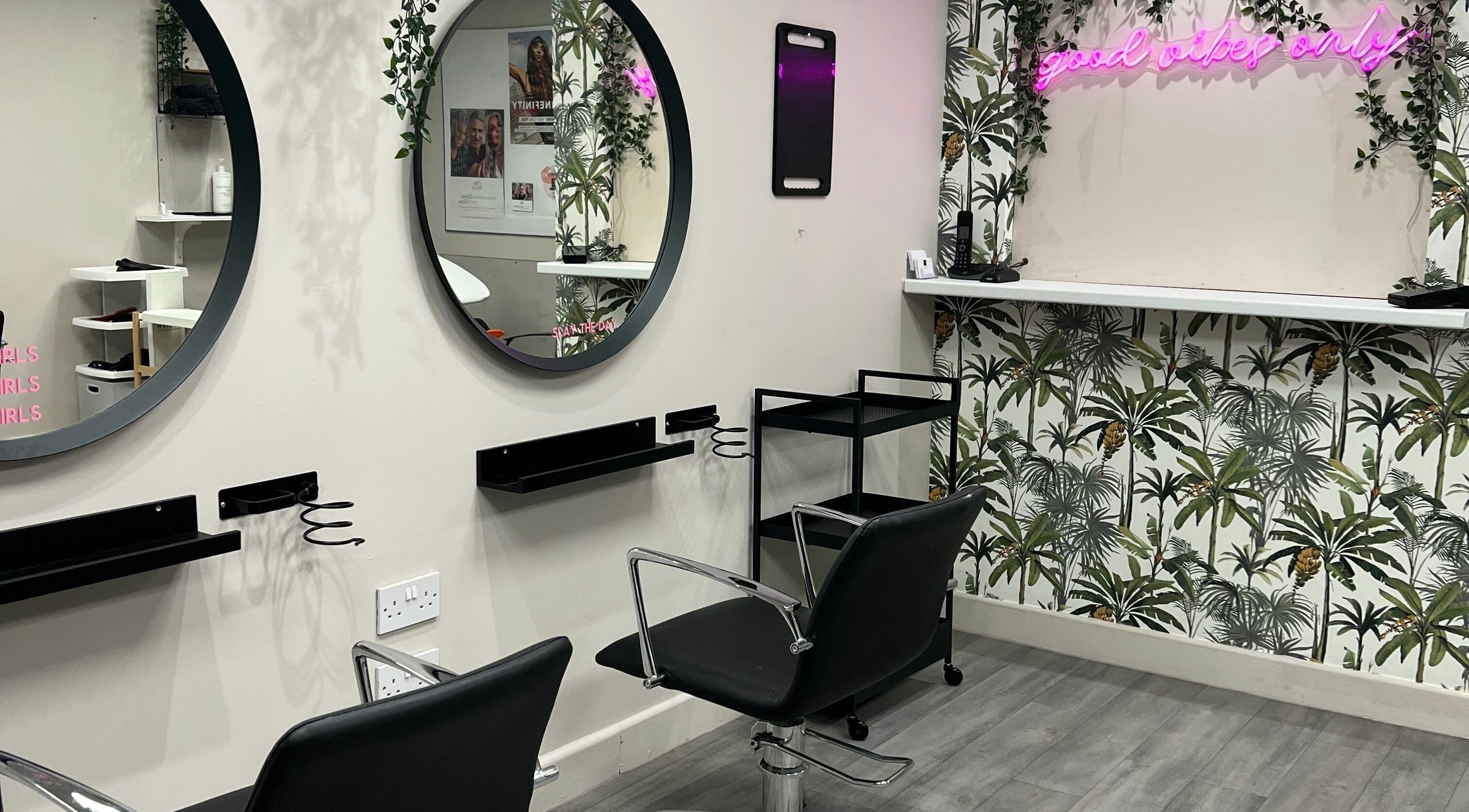 Modern salon interior at H2 Hair Salon, Whitchurch, England, GB featuring stylish mirrors and tropical decor.