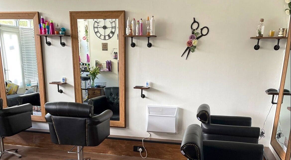 Modern salon interior at Belle Hair And Beauty in Falkirk, Scotland, GB with elegant mirrors and black chairs.