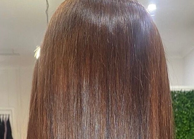 Glossy, straight auburn hair shines under salon lights at Polaris Hair Salon Raceview, Raceview, Queensland, AU.