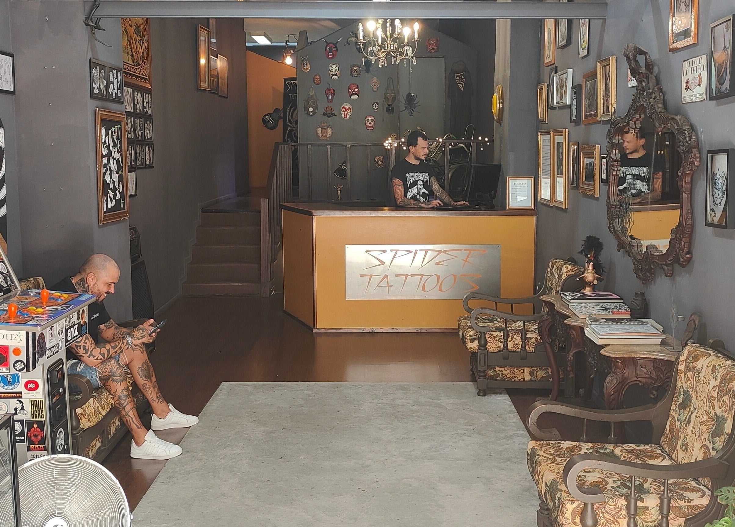 Interior acolhedor da SPIDER TATTOOS em Porto, Porto, PT, com obras e móveis vintage.