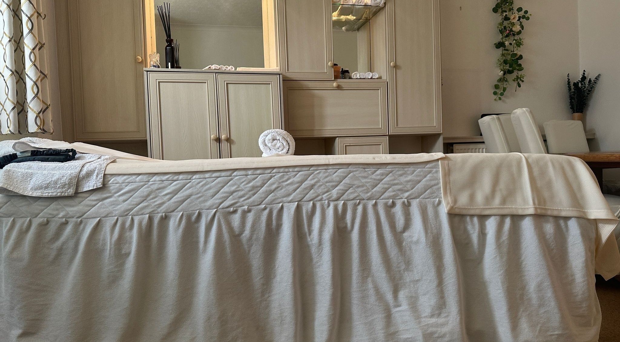 Luxurious massage room at The Science Of Wellness, Northwood, England, GB, featuring a plush treatment bed.