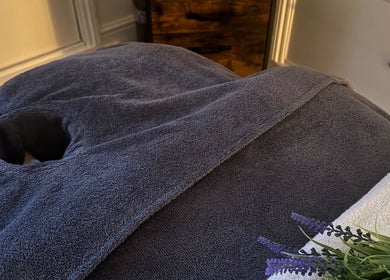 A cozy massage table setup in Chill Well-Being, Maidstone, England, GB with soft towels and lavender sprigs.