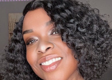 Smiling woman with styled curls at Passion Hair Solutions, Lanham, Maryland, US.