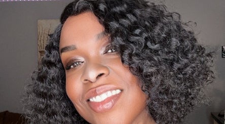 Smiling woman with styled curls at Passion Hair Solutions, Lanham, Maryland, US.