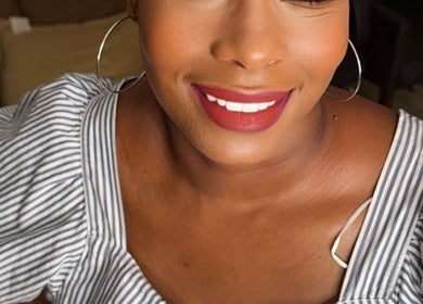 Smiling woman at Passion Hair Solutions, Lanham, Maryland, US, highlighting beauty services.