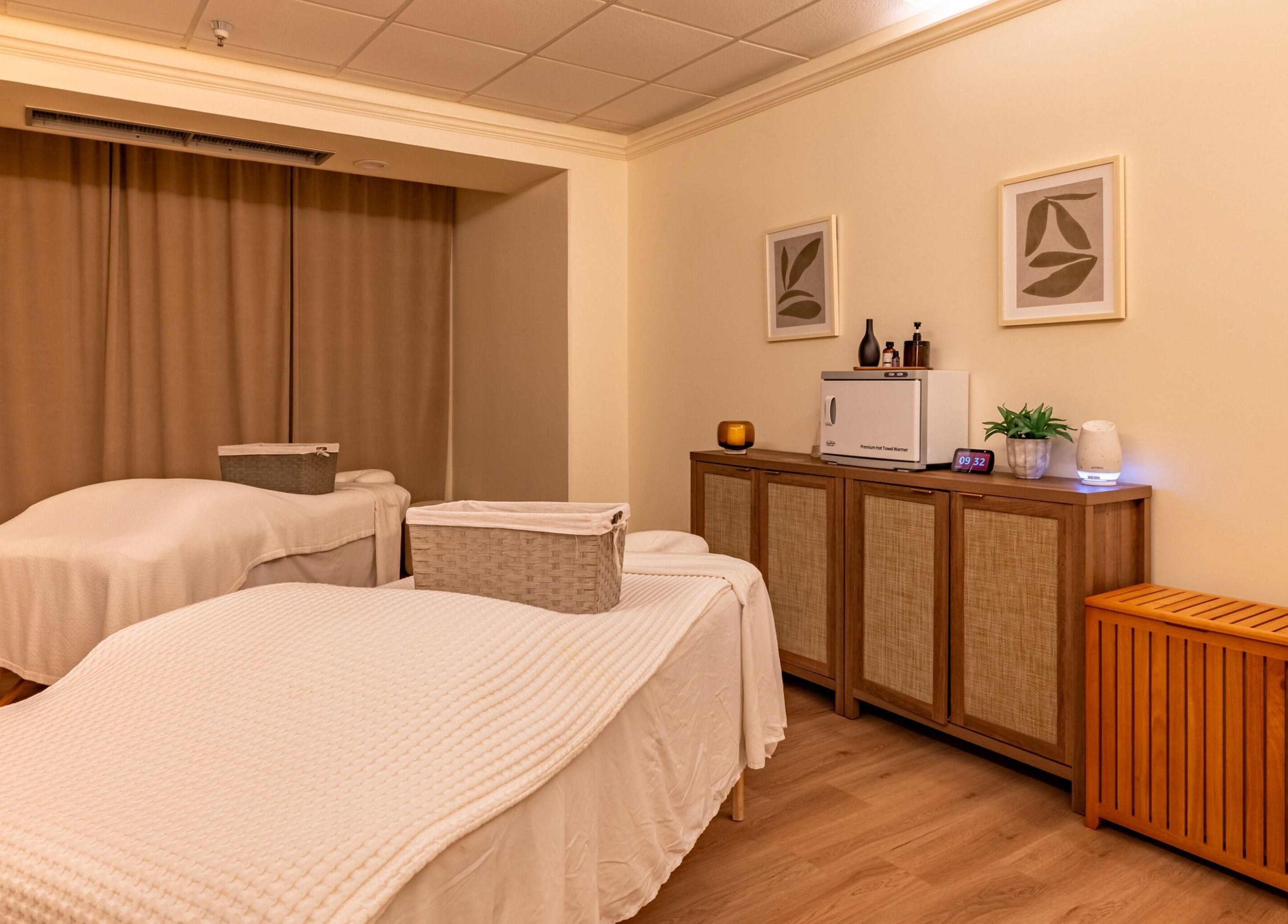 Calm treatment room at Asana Spa at Hilton Waikiki Beach, Honolulu, Hawaii, US, featuring massage tables and decor.