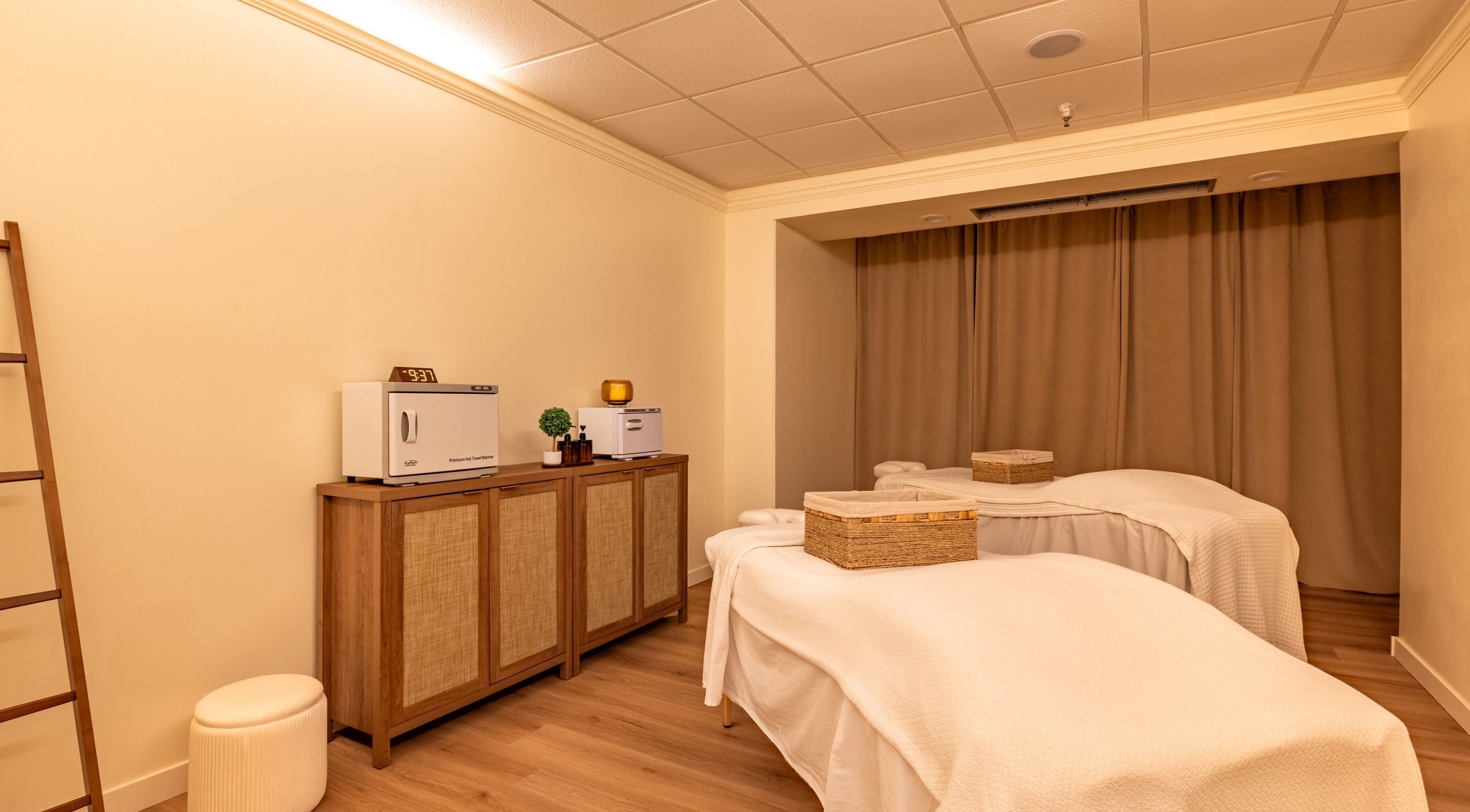Relaxing massage room at Asana Spa at Hilton Waikiki Beach, Honolulu, Hawaii, US featuring twin beds.