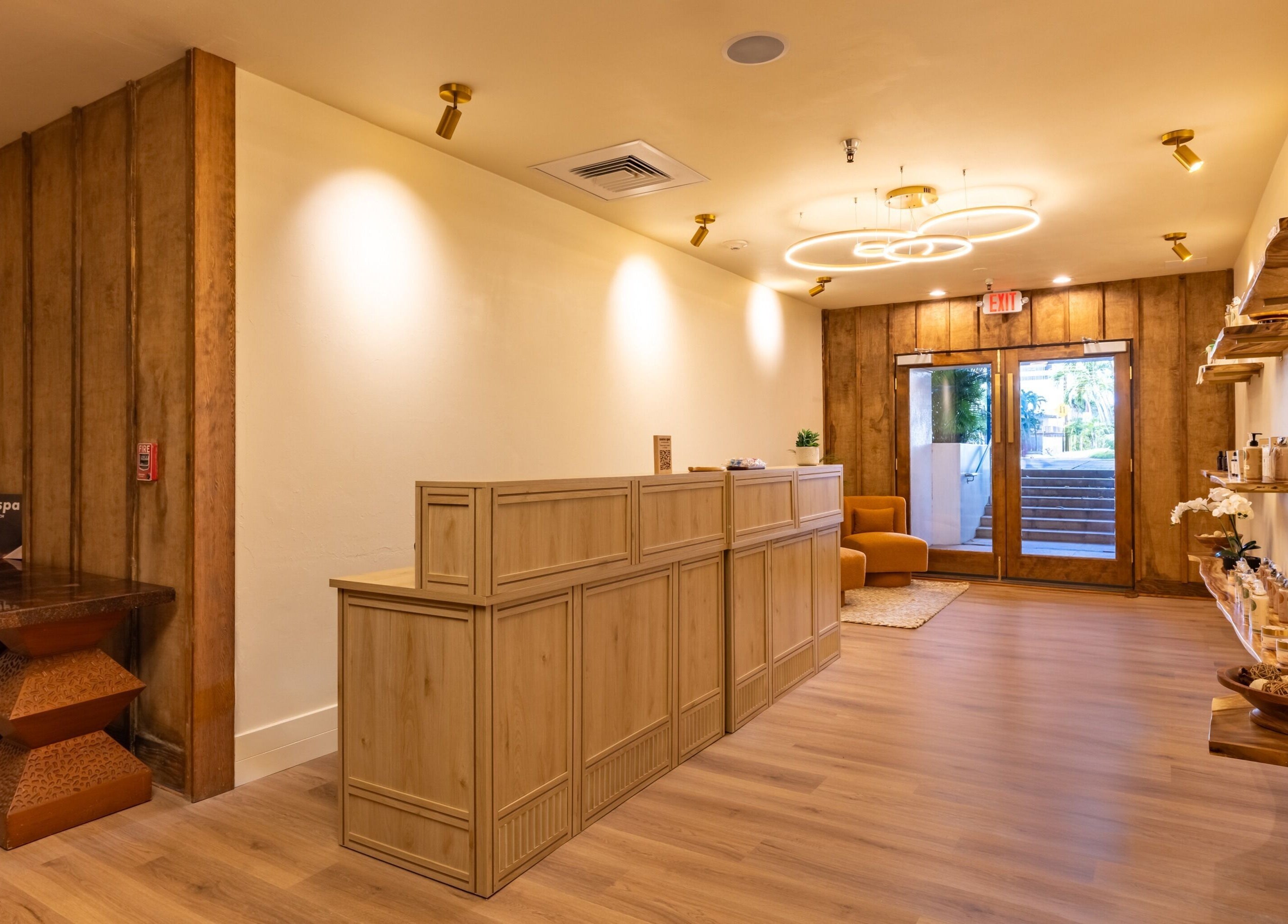 Reception area of Asana Spa at Hilton Waikiki Beach, Honolulu, Hawaii, US with warm lighting and wooden decor.