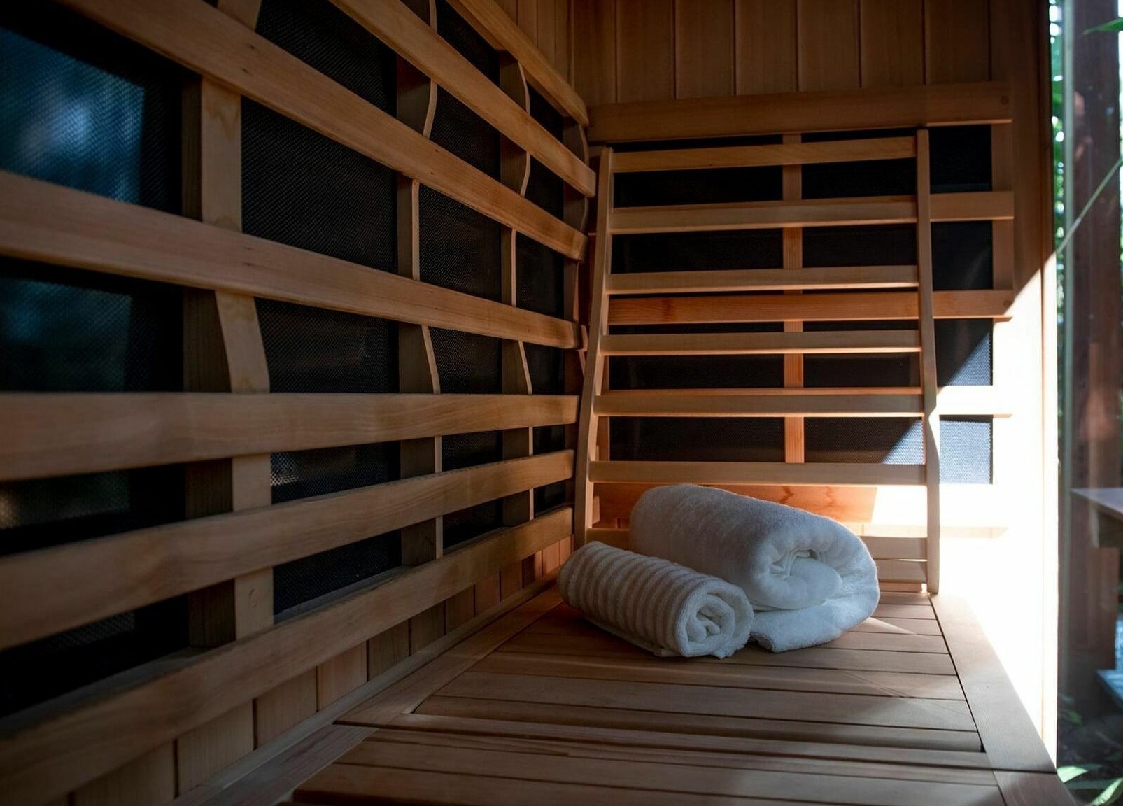 Interior of Cloud 9 Sauna with wooden benches and towels at Macmasters Beach, New South Wales, AU.