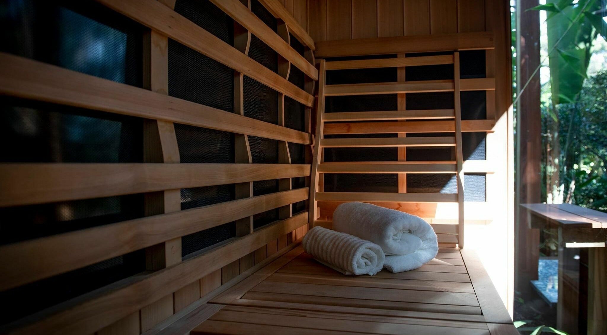 Interior of Cloud 9 Sauna with wooden benches and towels at Macmasters Beach, New South Wales, AU.