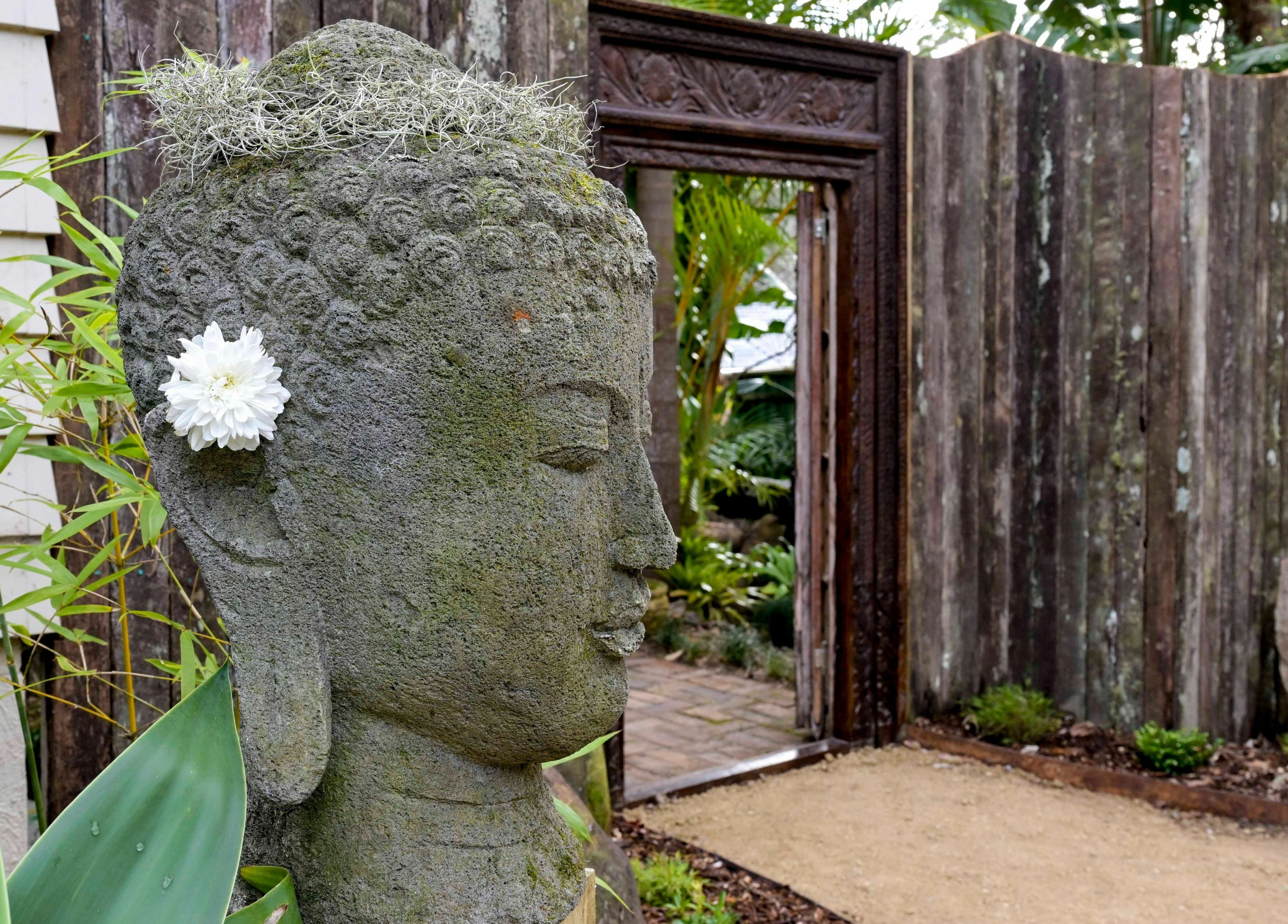 Buddha statue with flower at Cloud 9 Sauna entrance, Macmasters Beach, New South Wales, AU.