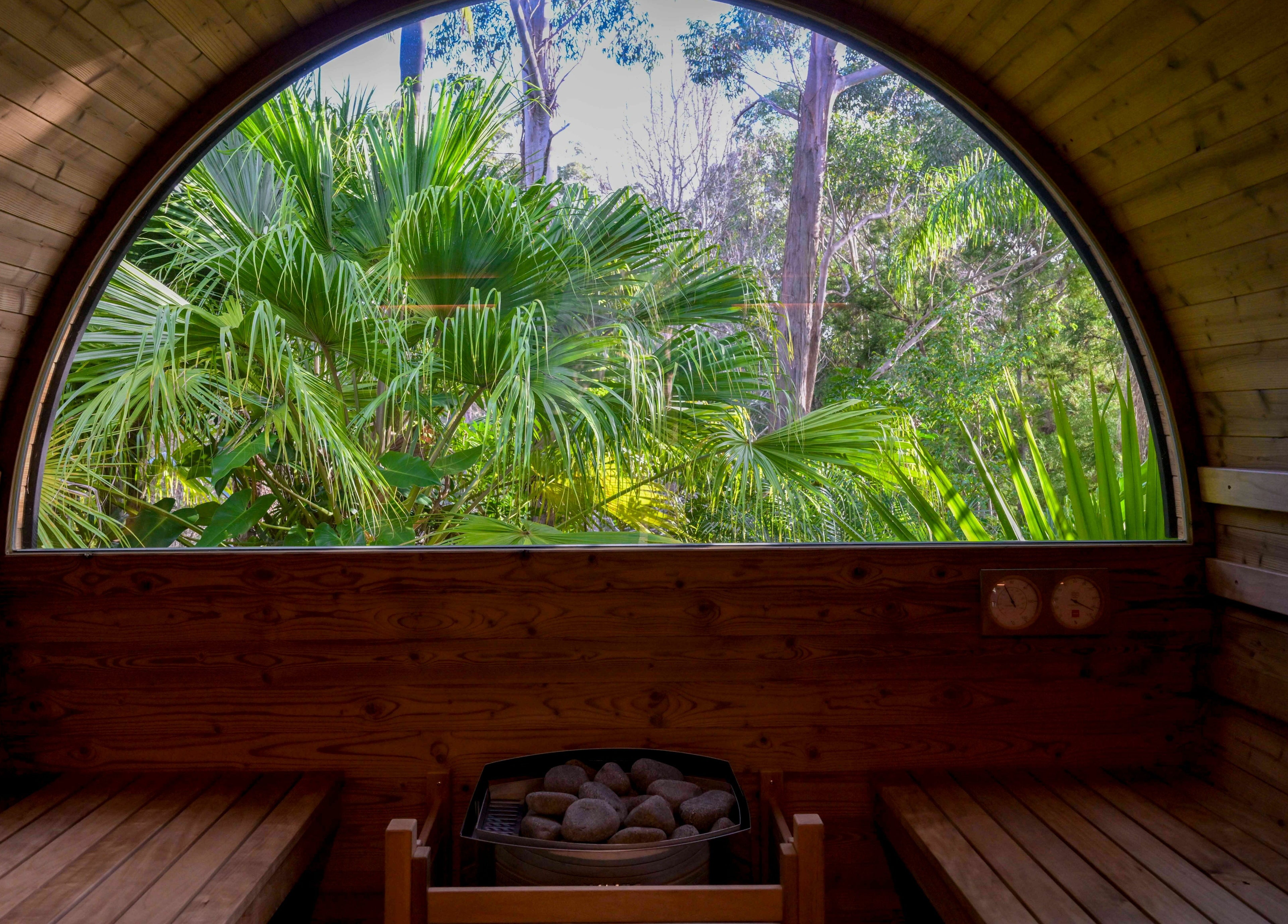 Serene wooden sauna interior with lush greenery view at Cloud 9 Sauna, Macmasters Beach, New South Wales, AU.