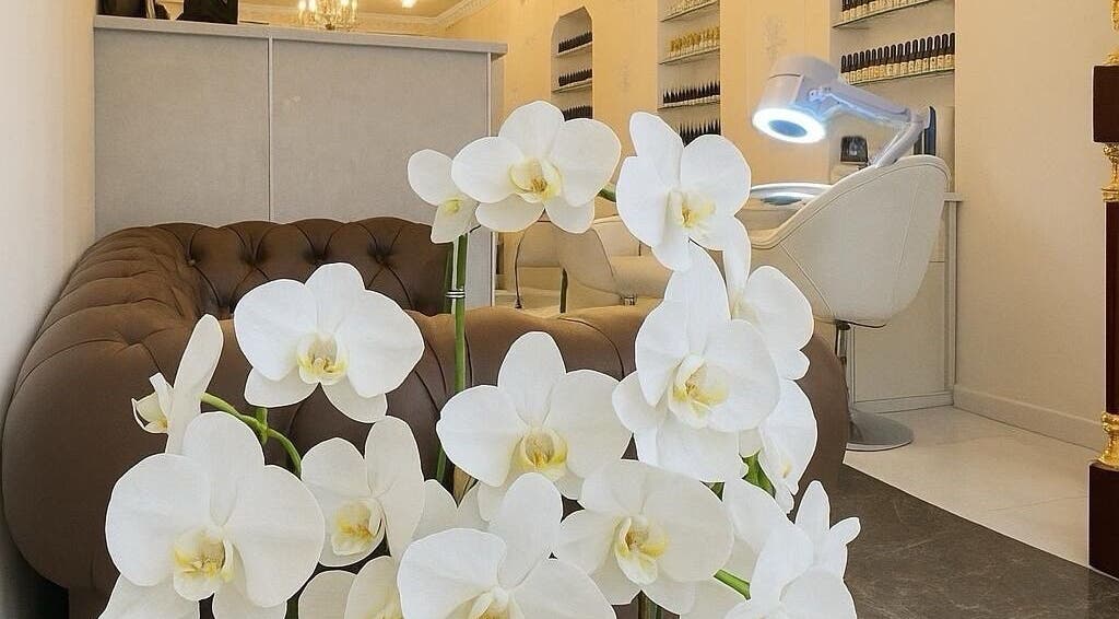 Intérieur élégant du salon RuzaNails à Marseille avec orchidées blanches et décor moderne.