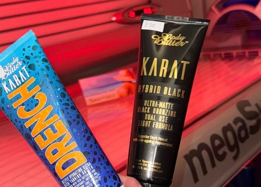 Suntan lotions displayed at CJP Nail And Beauty Bar in Havant, England, GB under red tanning lights.