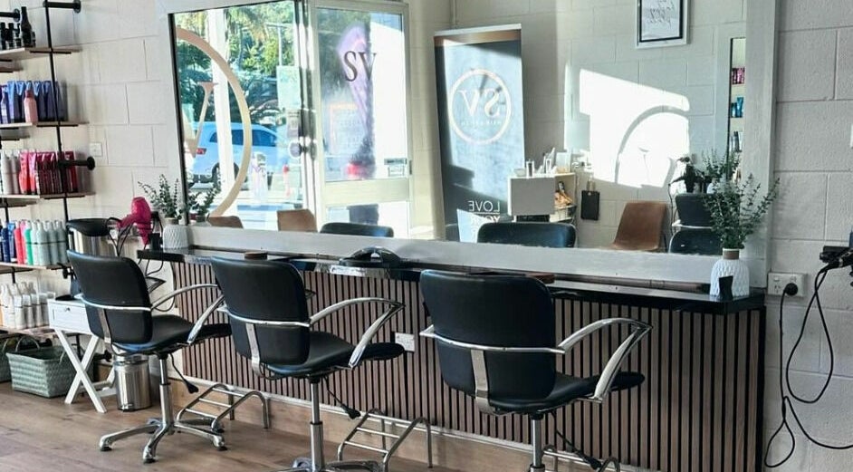 Modern styling area at SV Hair Design, Gladstone Central, Queensland, AU, with sleek chairs and products.