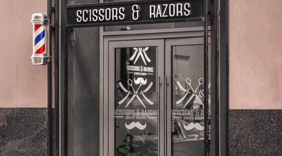 Scissors & Razors salon exterior with vintage barber pole in Dubai, AE.