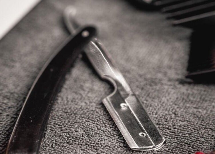 Close-up of a razor on a towel at Scissors & Razors, Dubai, AE, showcasing precision grooming tools.