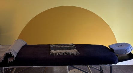 Comfortable massage table at Shep Sports Massage, London, England, GB, against a calming yellow backdrop.