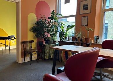 Vibrant interior of Shep Sports Massage in London, England, GB featuring colorful walls, plants, and a massage room.