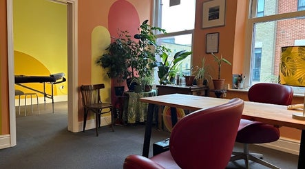 Vibrant interior of Shep Sports Massage in London, England, GB featuring colorful walls, plants, and a massage room.