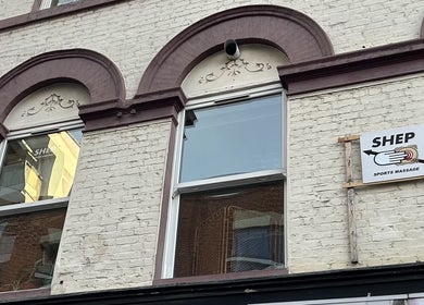 Exterior of Shep Sports Massage in London, England, GB with arched windows and a sign.