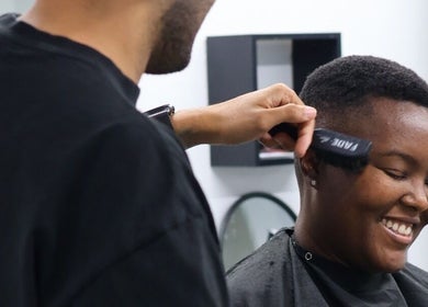 Cliente sonriente recibiendo corte de cabello en Loon Salon, San Juan, San Juan, PR.