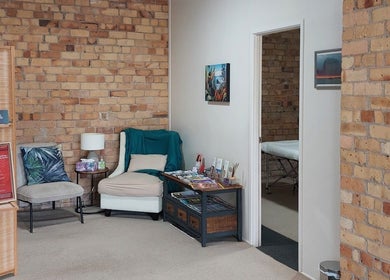 Relaxing seating area at Prime Massage Therapy (Onehunga), Auckland, NZ with brick walls and a massage room.