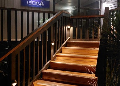 Inviting wooden steps at Prime Massage Therapy (West Auckland), Auckland, NZ, warmly lit for evening ambiance.