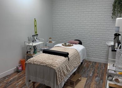 Salle de soin élégante à Brésilderme, Chambly, Québec, CA avec table de massage et décor apaisant.