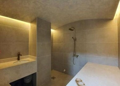 Elegant shower area with beige tiles at Shamsa Beauty Salon, Sharjah, AE, offering a soothing wellness retreat.