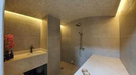 Elegant shower area with beige tiles at Shamsa Beauty Salon, Sharjah, AE, offering a soothing wellness retreat.