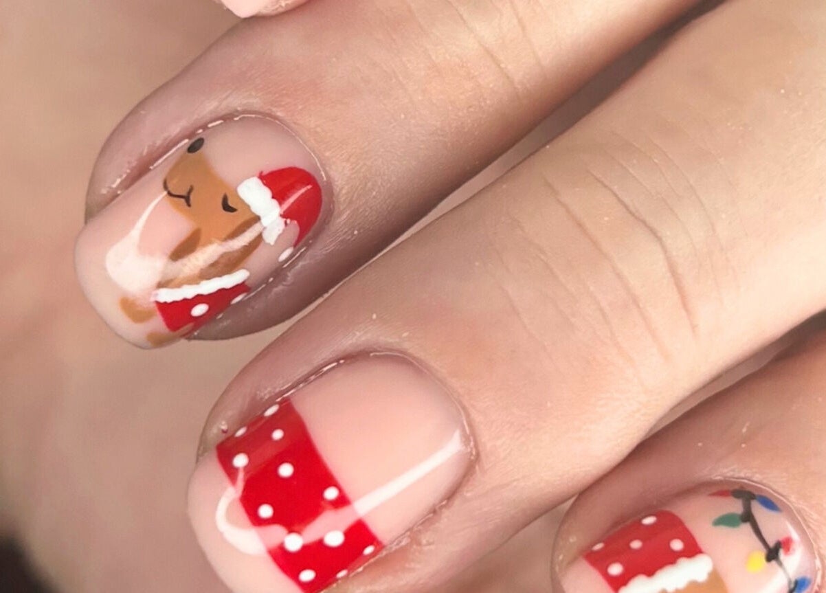 Christmas-themed nails at Mari-cles, Pretoria, Gauteng, ZA. Features reindeer, lights, and red accents.