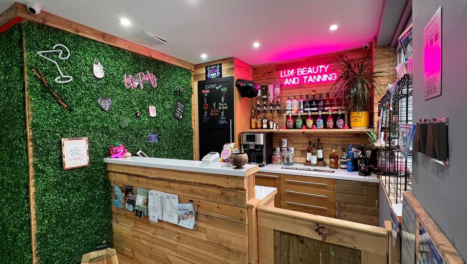Chic reception at LUX Beauty and Tanning LTD in Leabrooks, England. Inviting green wall and neon lights.