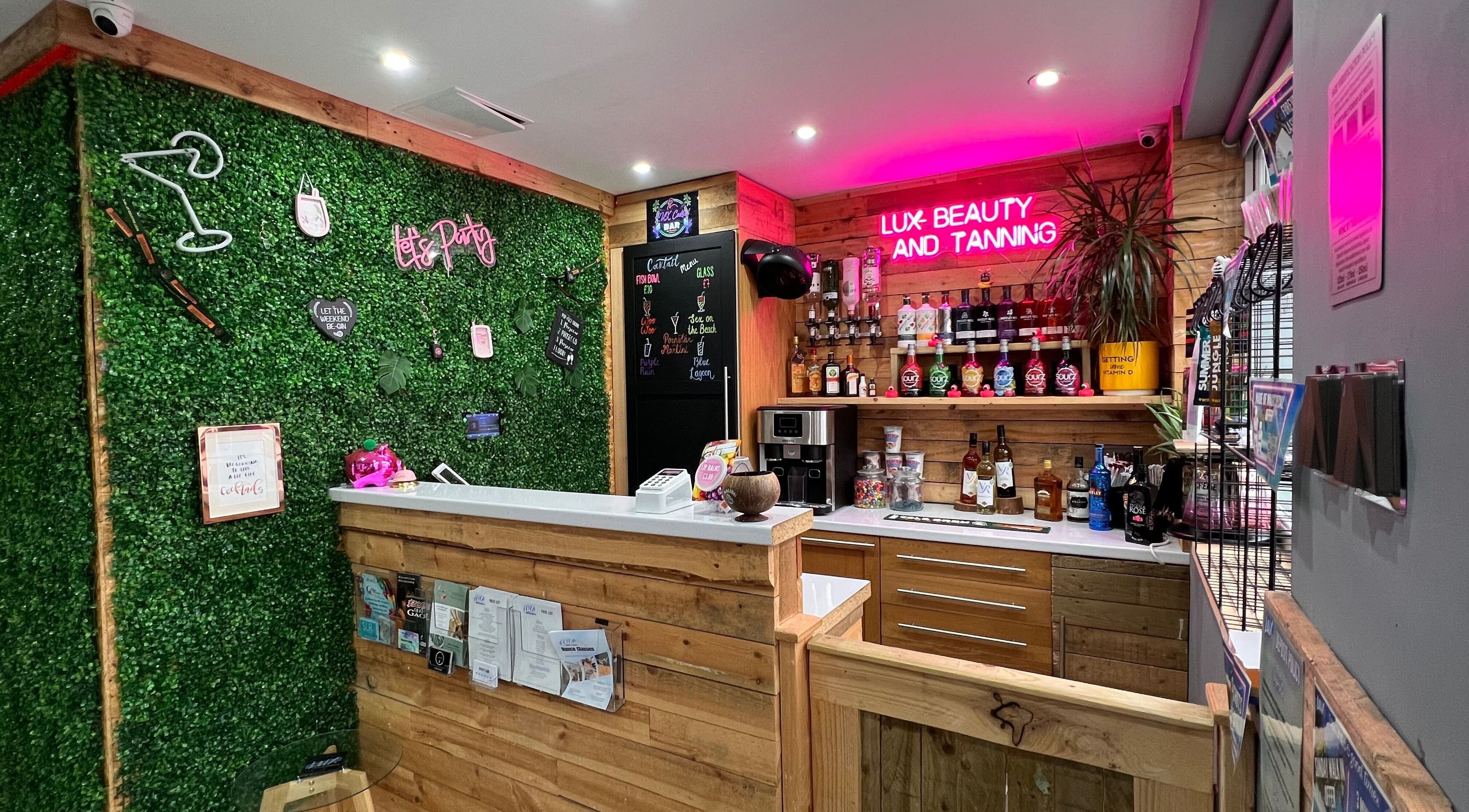 Chic reception at LUX Beauty and Tanning LTD in Leabrooks, England. Inviting green wall and neon lights.