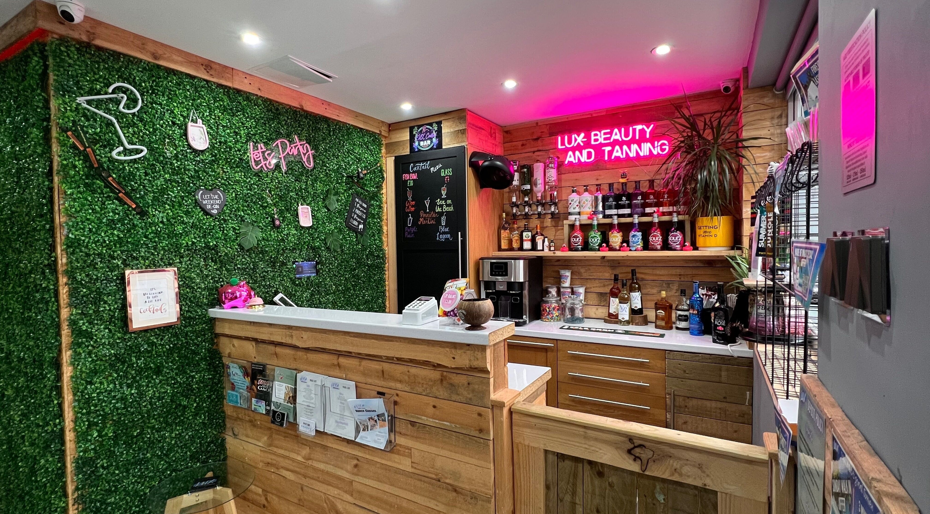 Chic reception at LUX Beauty and Tanning LTD in Leabrooks, England. Inviting green wall and neon lights.