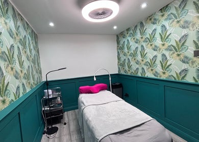 Relaxing treatment room at LUX Beauty and Tanning LTD, Leabrooks, England, with tropical leaf decor.