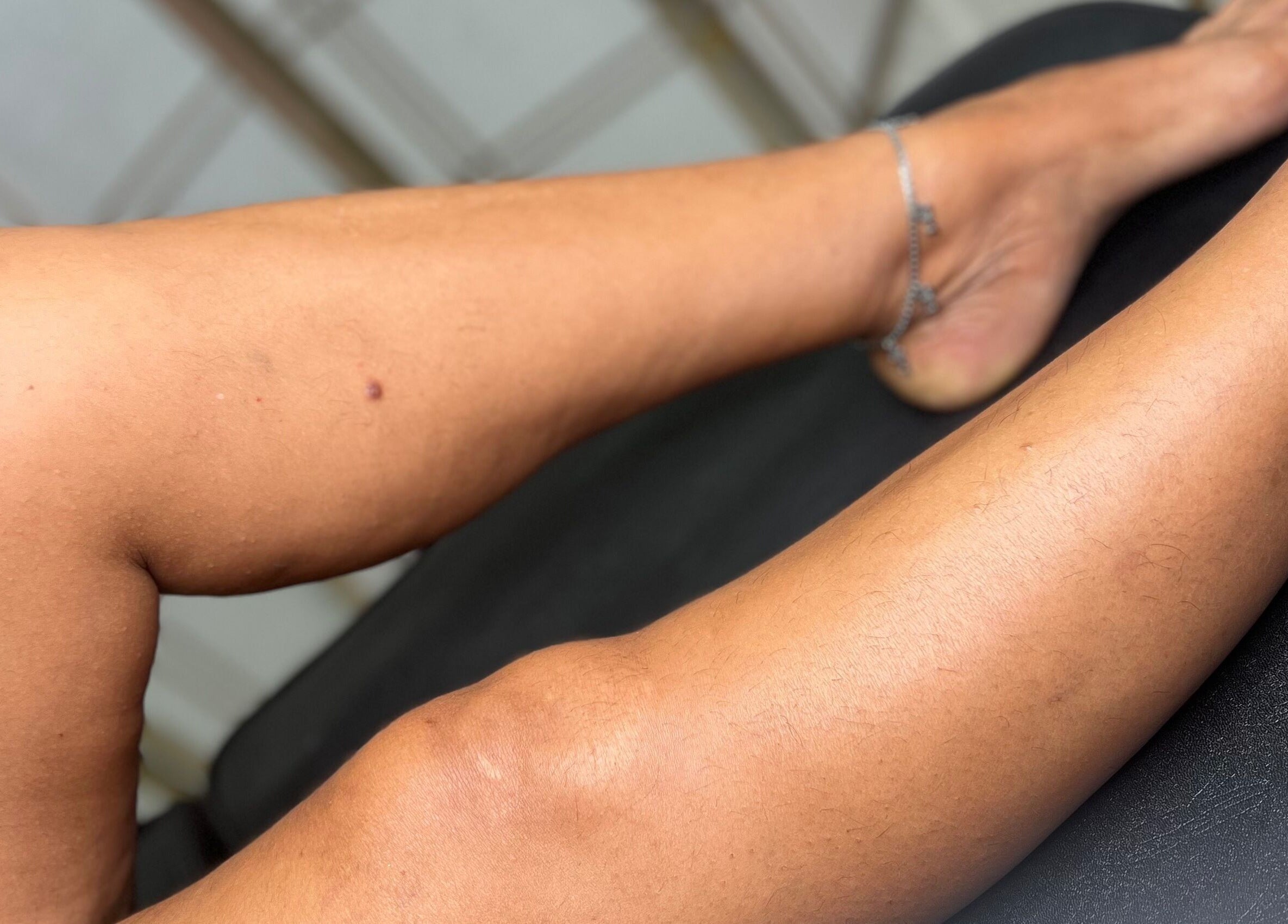 Close-up of tattooed leg on a black surface at Ethereal Beauty, Willemstad, Curaçao, CW.