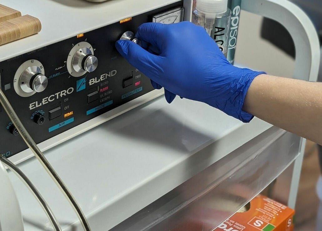 Technician adjusts electrolysis machine at Clarico Electrolysis + Advanced Aesthetics, Vancouver, British Columbia, CA.