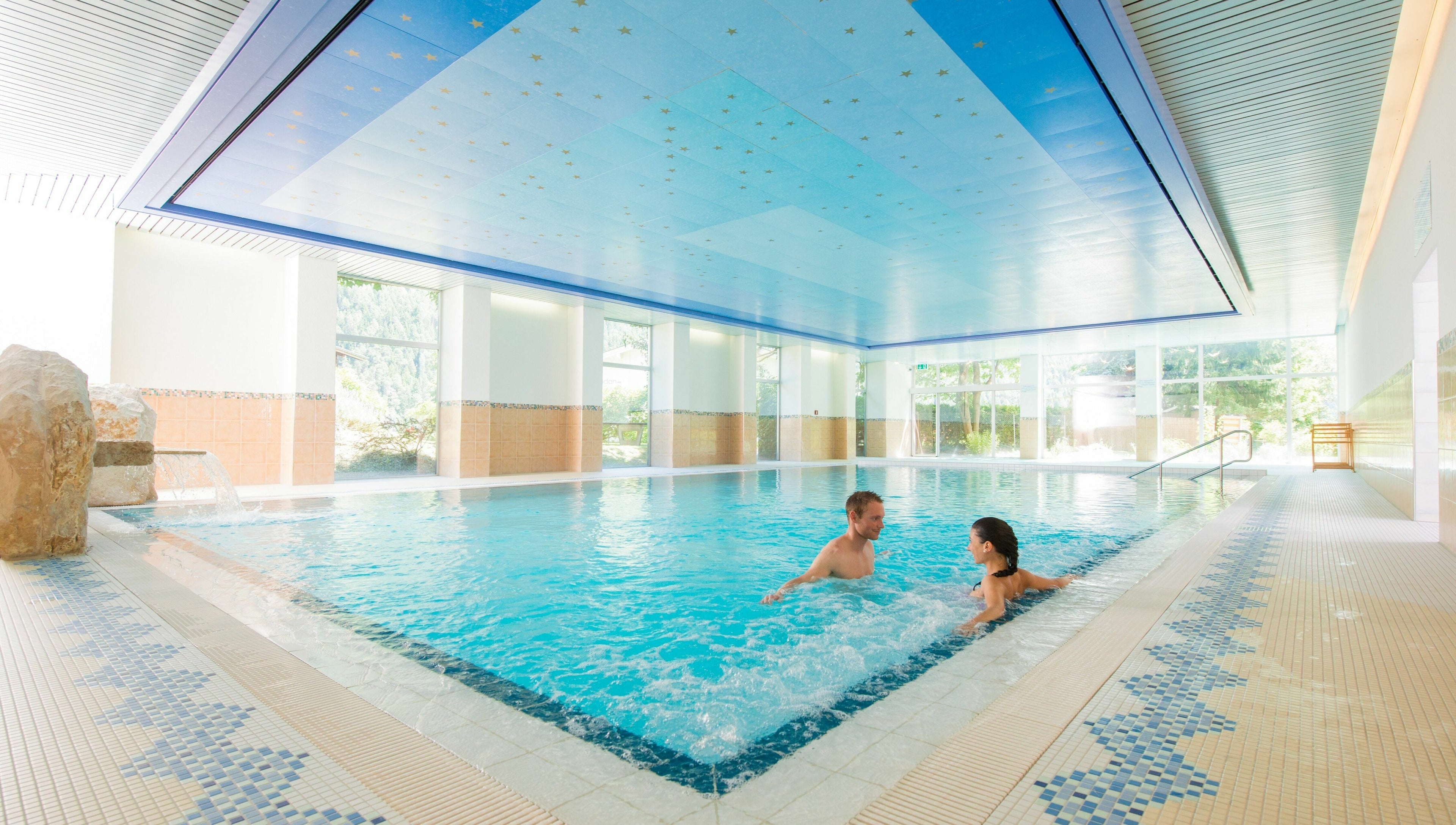 Innenpool von Badehotel Salina Maris, Breiten Ob Mörel, Wallis, CH, mit Gästen entspannt im klaren Wasser.