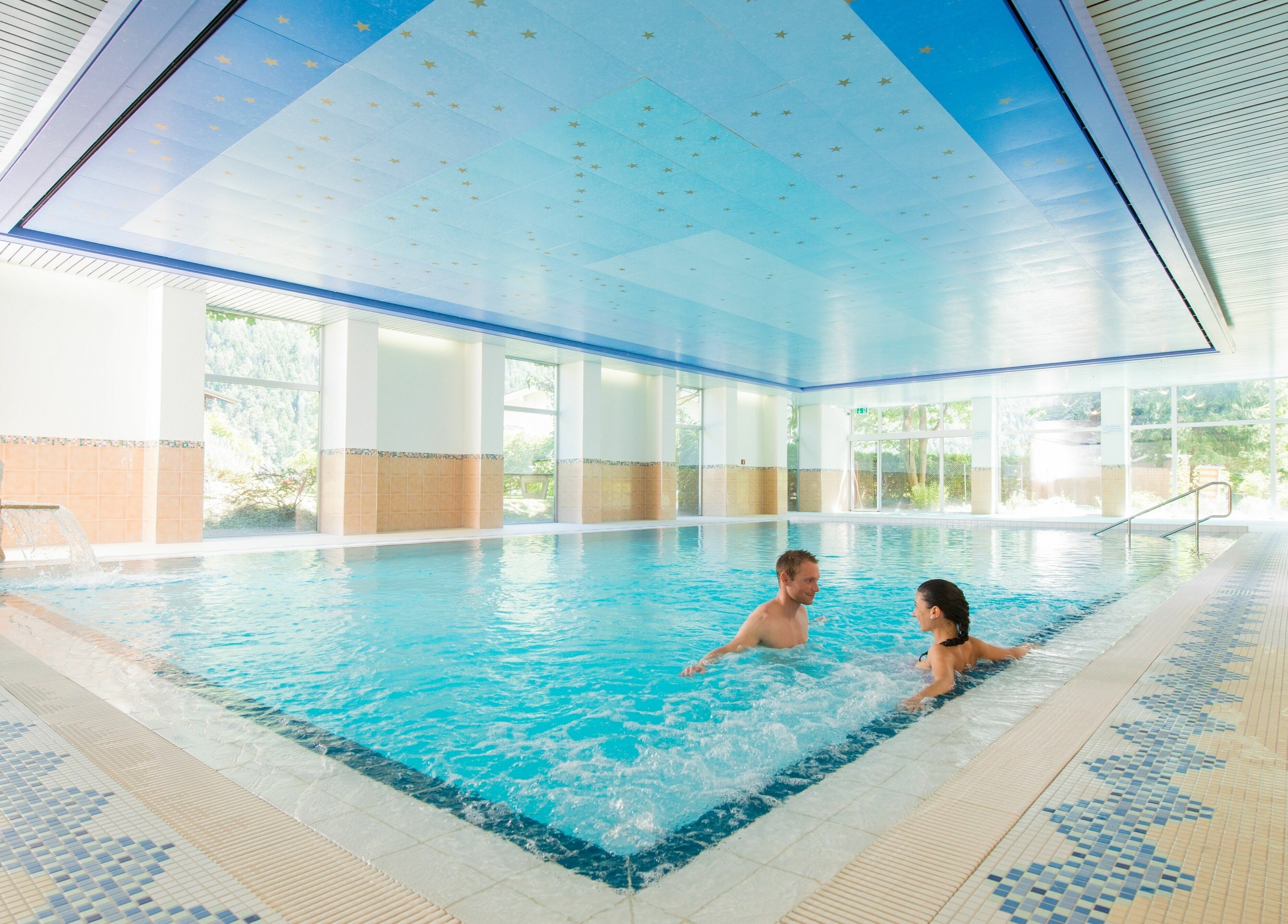 Innenpool von Badehotel Salina Maris, Breiten Ob Mörel, Wallis, CH, mit Gästen entspannt im klaren Wasser.