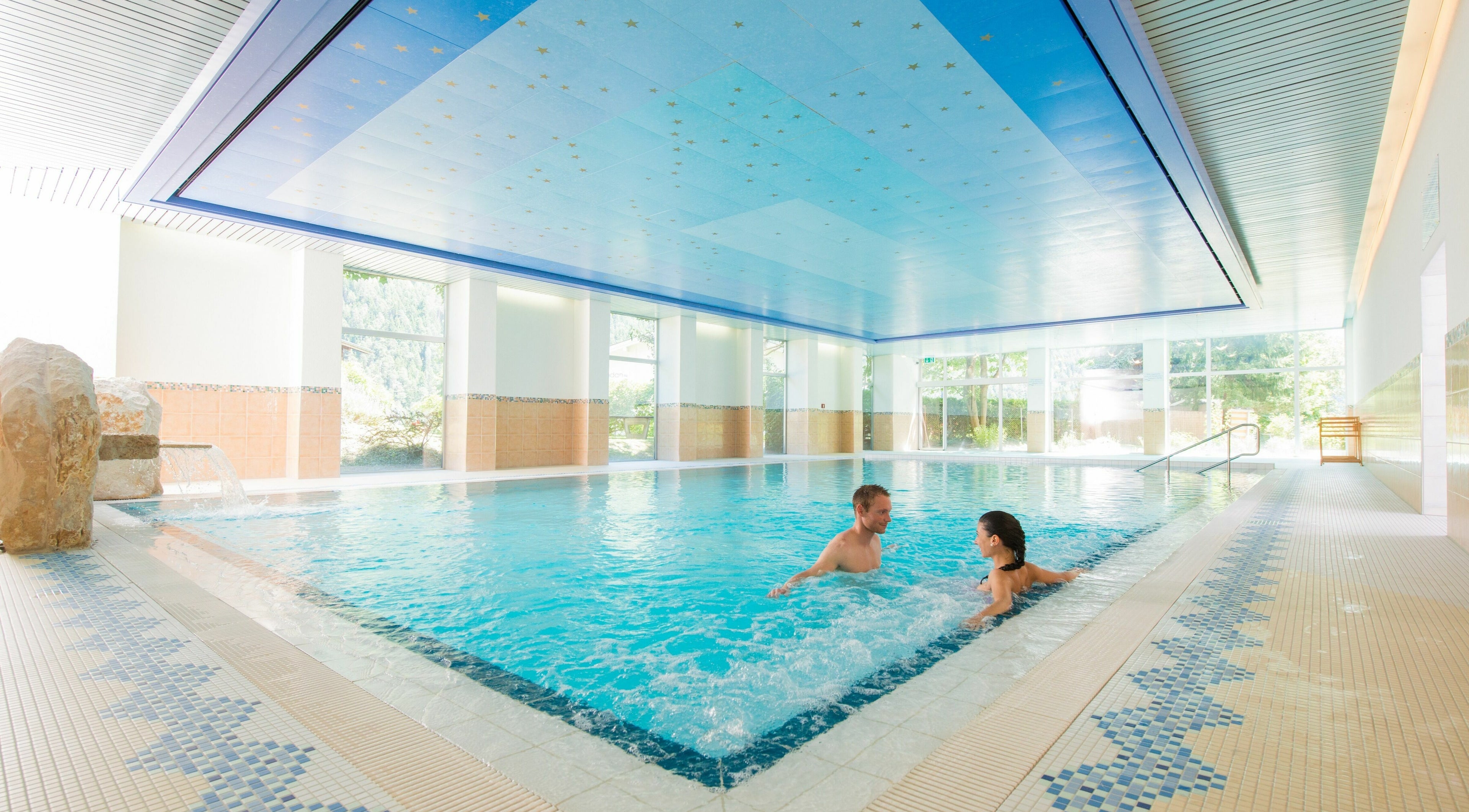 Innenpool von Badehotel Salina Maris, Breiten Ob Mörel, Wallis, CH, mit Gästen entspannt im klaren Wasser.