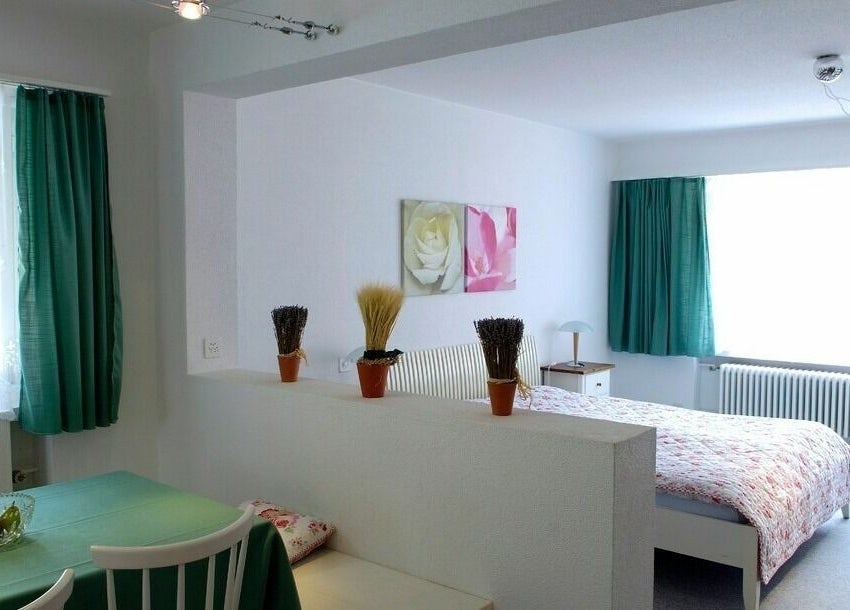 Helles Zimmer mit grünen Vorhängen im Badehotel Salina Maris, Breiten Ob Mörel, Wallis, CH.