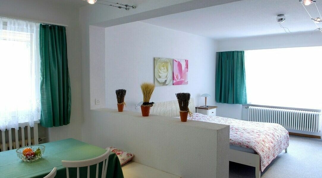 Helles Zimmer mit grünen Vorhängen im Badehotel Salina Maris, Breiten Ob Mörel, Wallis, CH.