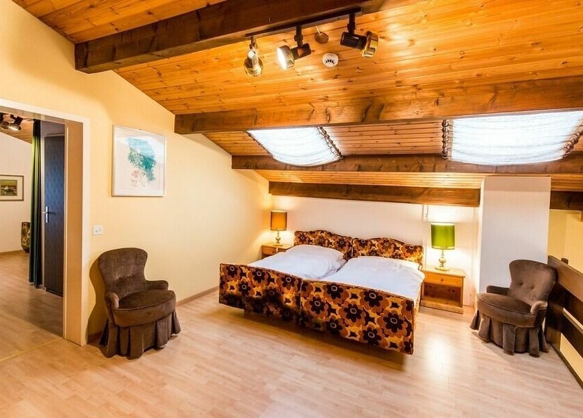 Gemütliches Gästezimmer im Badehotel Salina Maris, Breiten Ob Mörel, Wallis, CH mit rustikaler Holzdachdecke.
