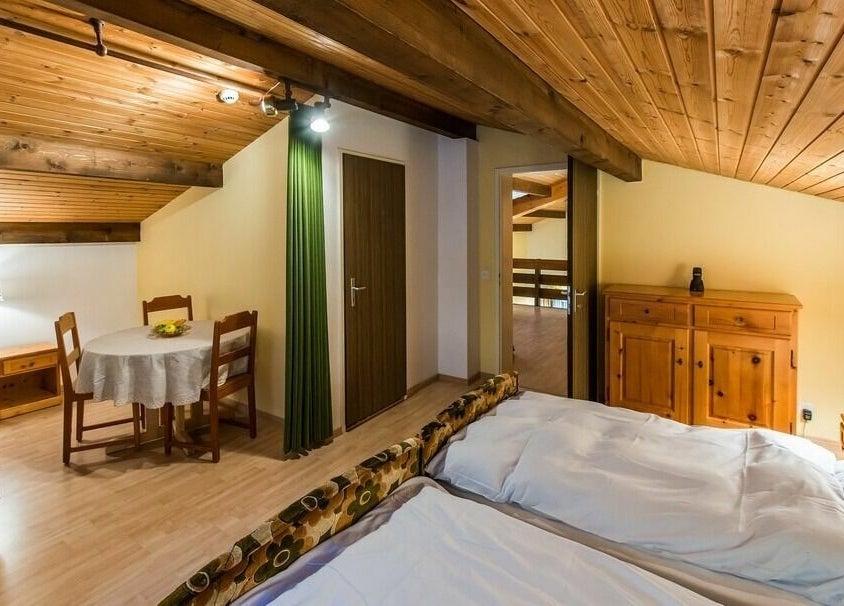 Gemütliches Zimmer im Badehotel Salina Maris in Breiten Ob Mörel, Wallis, CH, mit Holzdecke und Esstisch.