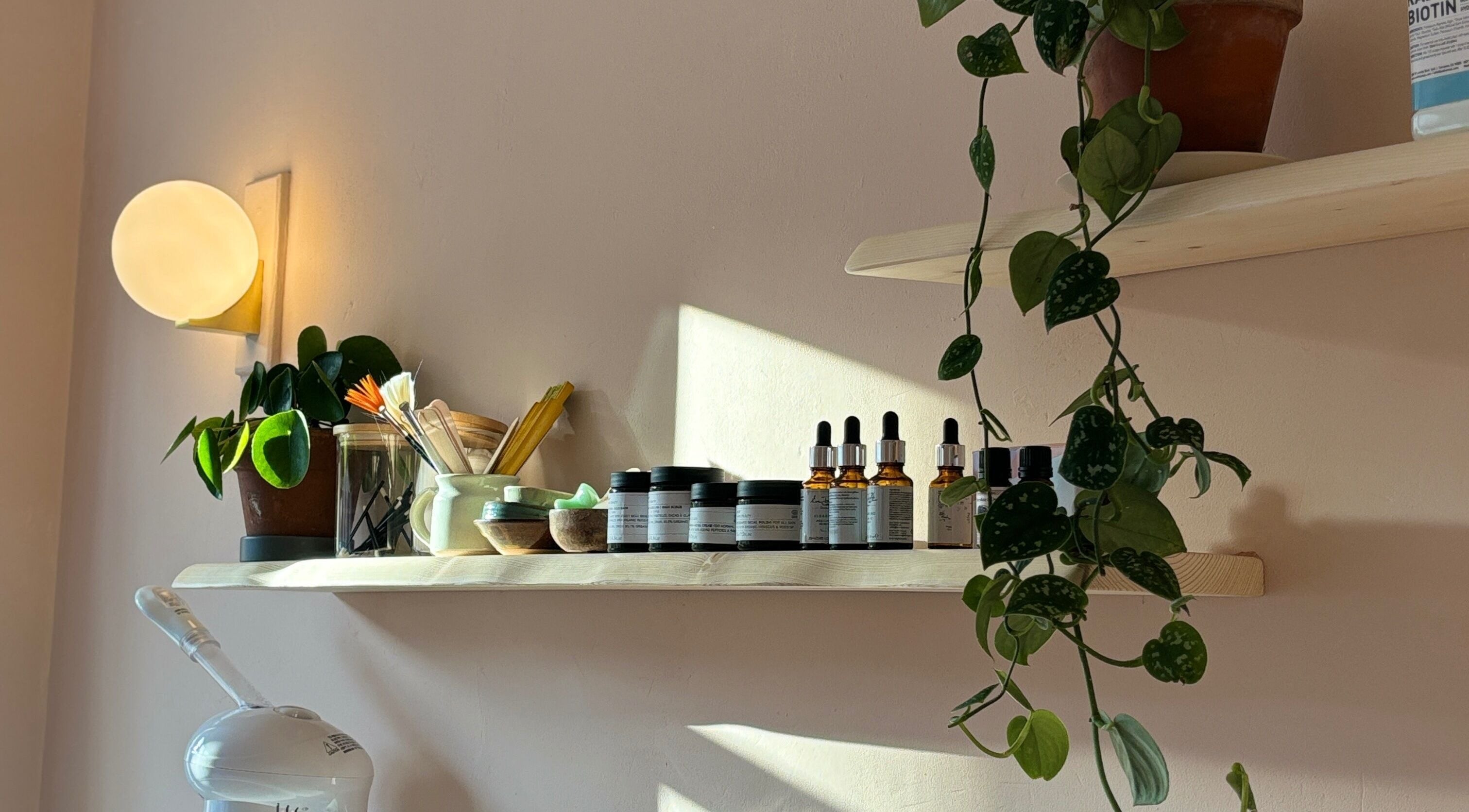 Natural skincare products on light-wooden shelf at Coral Beauty, Bournemouth, England, GB.